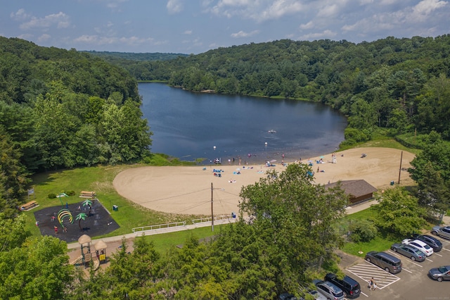 birds eye view of property with a wooded view and a water view