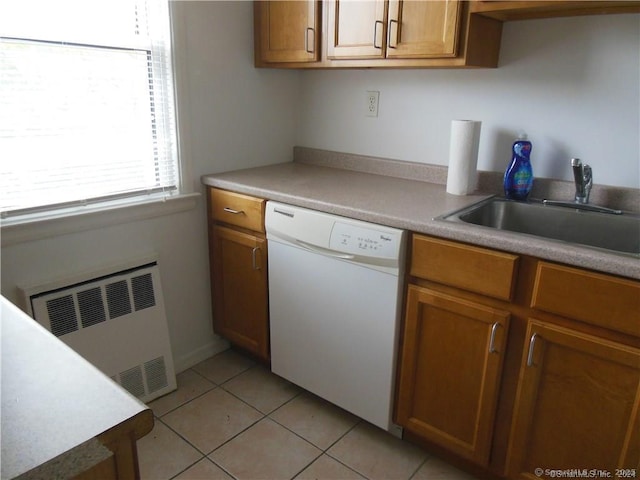 kitchen featuring radiator, light tile patterned floors, a sink, dishwasher, and brown cabinets