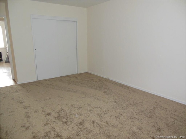 unfurnished bedroom featuring a closet, carpet flooring, and baseboards