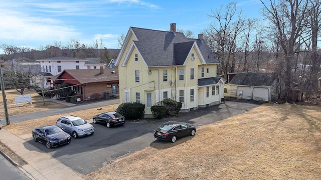 exterior space with an outbuilding, a residential view, and a chimney