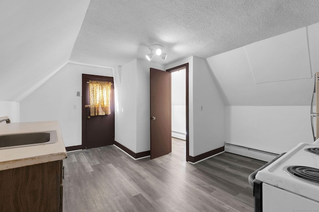 kitchen with a sink, a baseboard heating unit, a textured ceiling, and electric stove