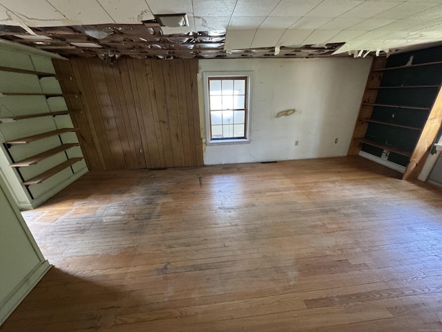 unfurnished room featuring wood finished floors and wood walls