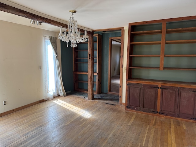 interior space featuring hardwood / wood-style flooring, baseboards, and a chandelier