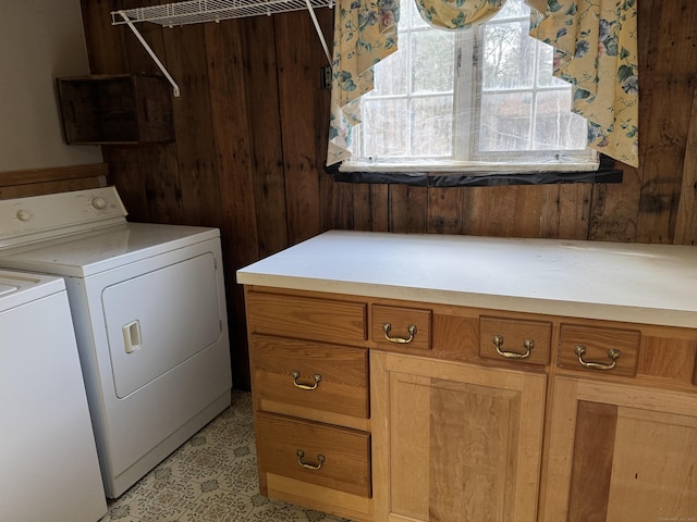 clothes washing area with washing machine and clothes dryer and cabinet space