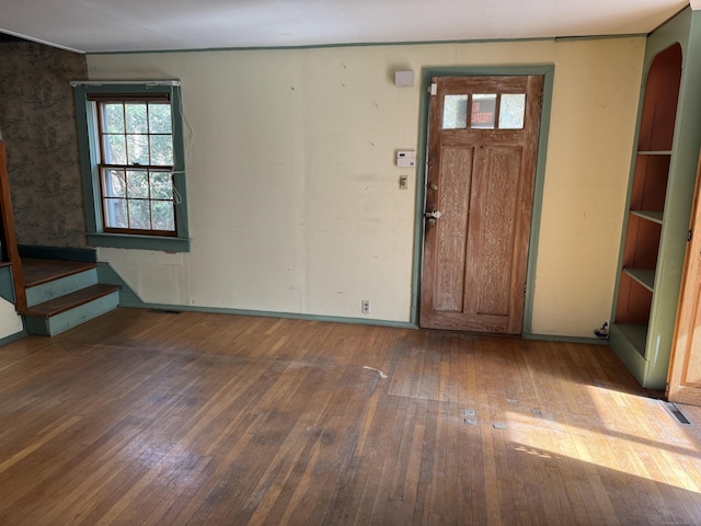 entrance foyer with hardwood / wood-style floors, stairs, baseboards, and arched walkways