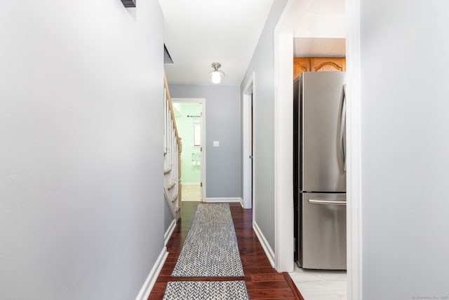 hall featuring light wood-type flooring, baseboards, and stairway