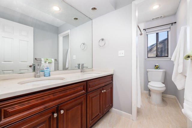 full bath with double vanity, visible vents, baseboards, and a sink