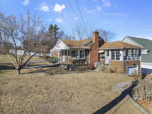 back of property with a porch, roof with shingles, a chimney, and fence