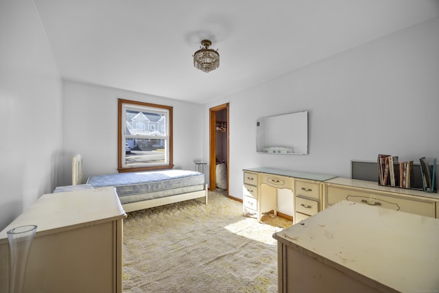 bedroom with light colored carpet, a walk in closet, and baseboards