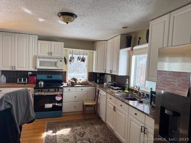 kitchen featuring a sink, appliances with stainless steel finishes, and white cabinetry