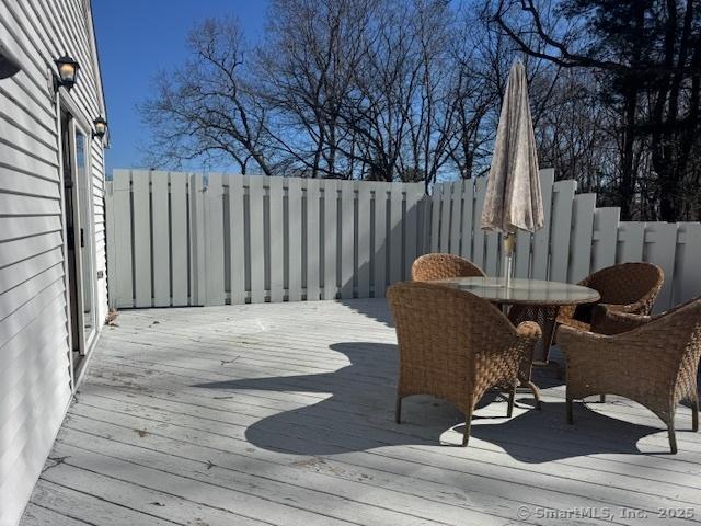 deck with outdoor dining area and fence