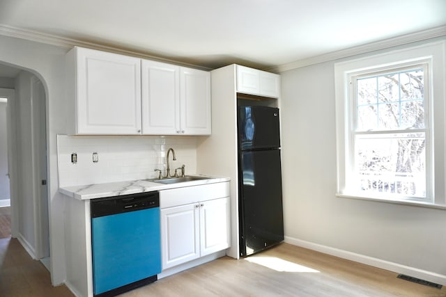 kitchen featuring visible vents, freestanding refrigerator, a sink, decorative backsplash, and dishwasher