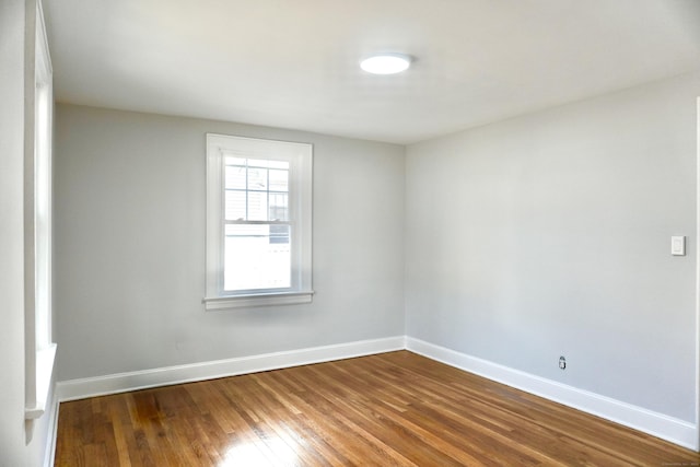 empty room with baseboards and wood finished floors