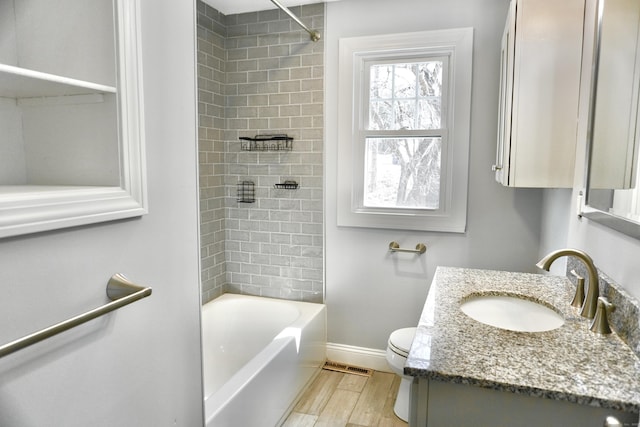 bathroom with vanity, wood finished floors, visible vents, baseboards, and toilet