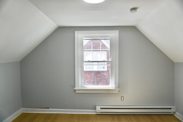 additional living space with wood finished floors, baseboards, and a baseboard radiator