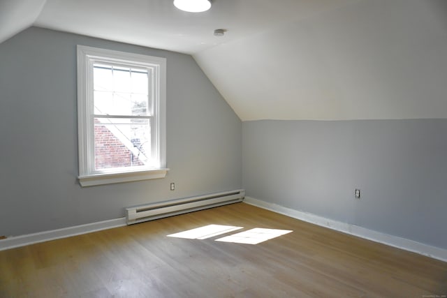 bonus room with baseboards, baseboard heating, lofted ceiling, and wood finished floors