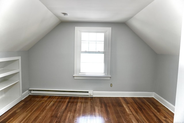 additional living space with built in shelves, dark wood-style floors, baseboards, a baseboard radiator, and vaulted ceiling