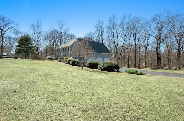 view of home's exterior with a lawn, an attached garage, and driveway