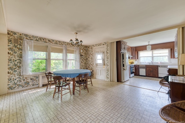 673 Spring St, Manchester, CT 06040 - dining room featuring wallpapered walls, a chandelier, brick patterned floors, radiator, and baseboards