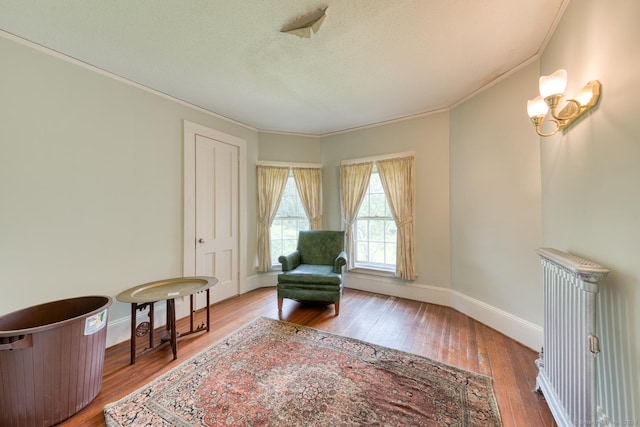 673 Spring St, Manchester, CT 06040 - living area with ornamental molding, hardwood / wood-style flooring, baseboards, and a textured ceiling