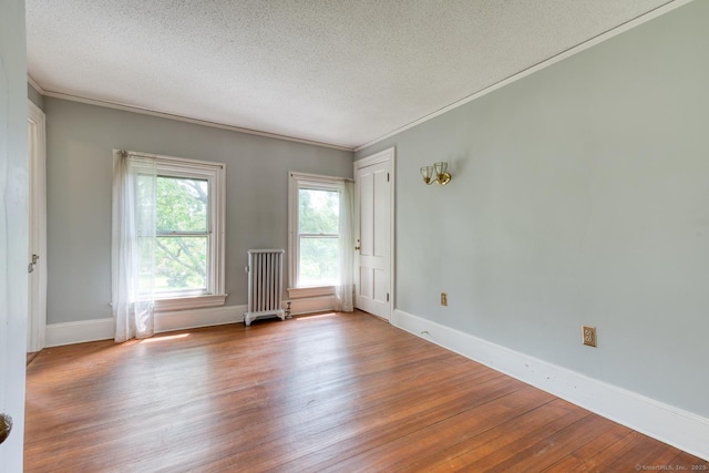 673 Spring St, Manchester, CT 06040 - spare room featuring radiator heating unit, wood finished floors, a textured ceiling, ornamental molding, and baseboards