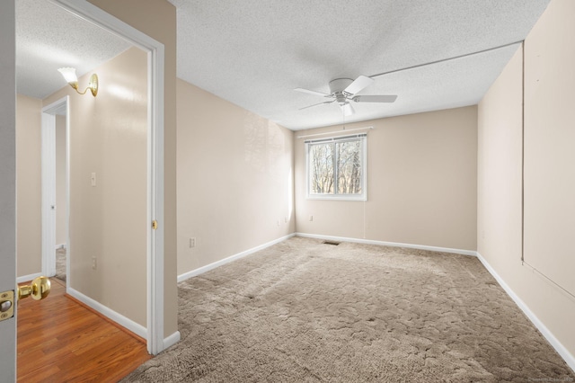 unfurnished room featuring baseboards, a textured ceiling, light carpet, and ceiling fan