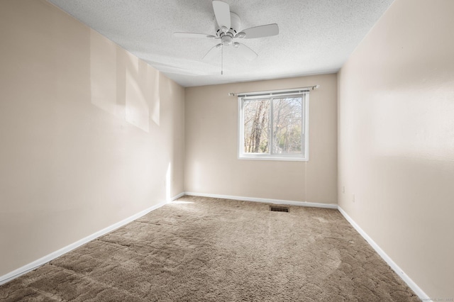 carpeted spare room with visible vents, baseboards, a textured ceiling, and ceiling fan