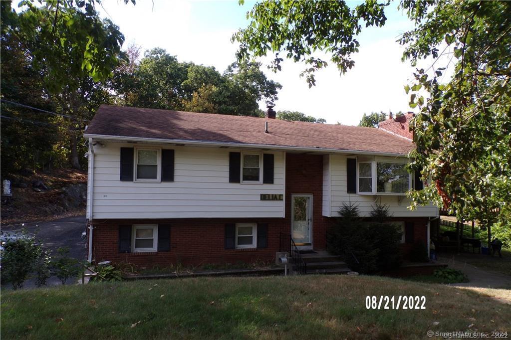 65 Harvard Ave, Shelton, CT 06484 - bi-level home featuring a front lawn, brick siding, a chimney, and entry steps