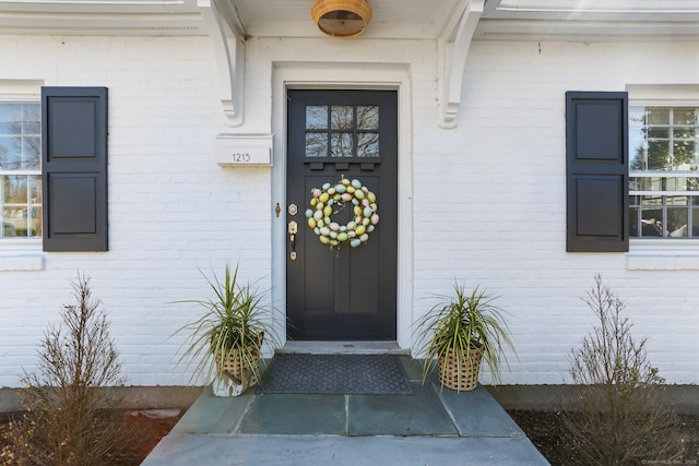 view of exterior entry featuring brick siding