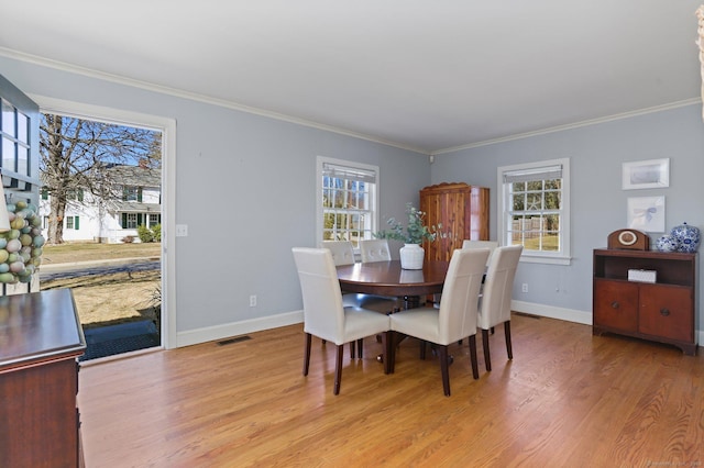 dining area featuring light wood finished floors, visible vents, a healthy amount of sunlight, and baseboards