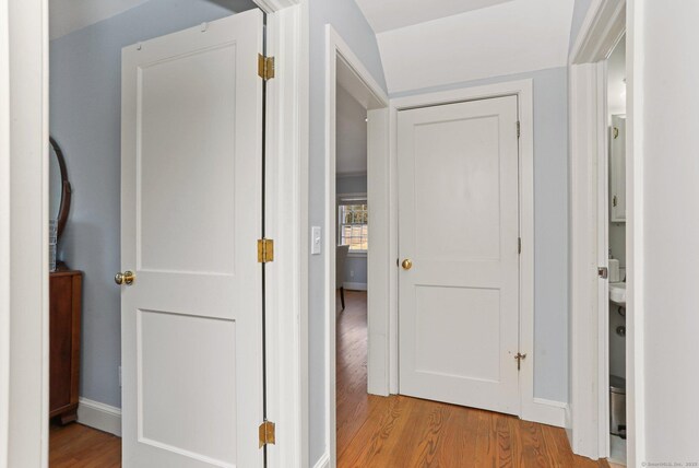 hallway with baseboards and light wood-style floors