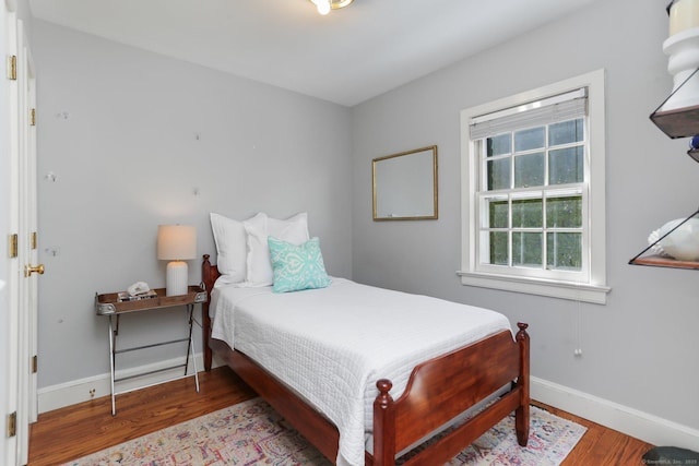 bedroom with baseboards and wood finished floors