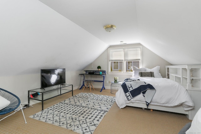 bedroom with baseboards, lofted ceiling, and carpet floors