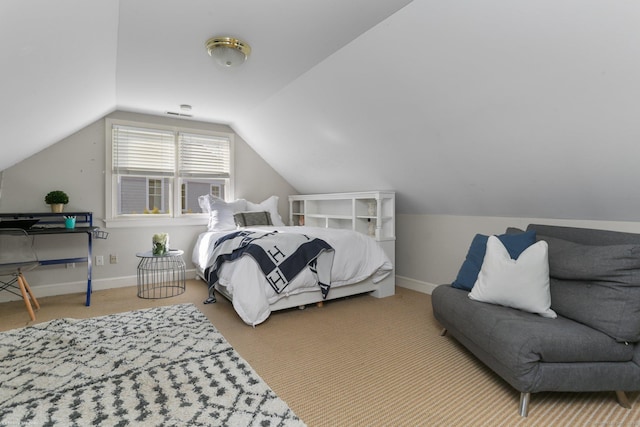 carpeted bedroom with lofted ceiling and baseboards