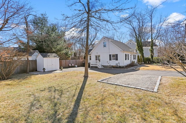 view of yard with a storage shed, an outdoor structure, and fence