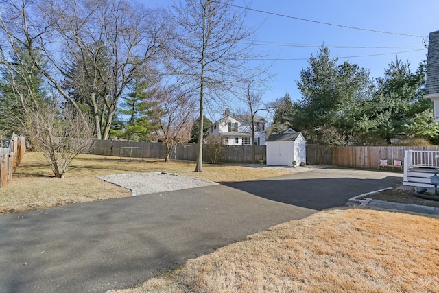 view of yard with an outbuilding, a fenced backyard, and a shed