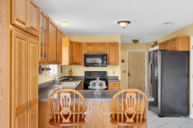 686 W Rd, Salem, CT 06420 - kitchen featuring black appliances, a peninsula, a sink, dark countertops, and a breakfast bar area