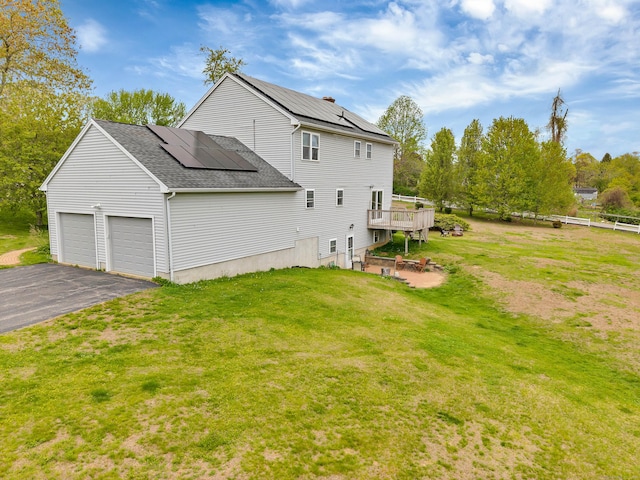 686 W Rd, Salem, CT 06420 - back of property with roof with shingles, a yard, driveway, roof mounted solar panels, and an attached garage