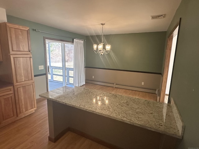 kitchen featuring visible vents, a chandelier, wood finished floors, hanging light fixtures, and a baseboard radiator