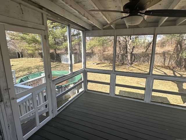 unfurnished sunroom featuring a ceiling fan