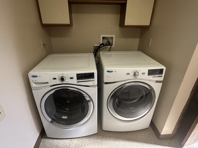 clothes washing area with laundry area, baseboards, and washing machine and clothes dryer