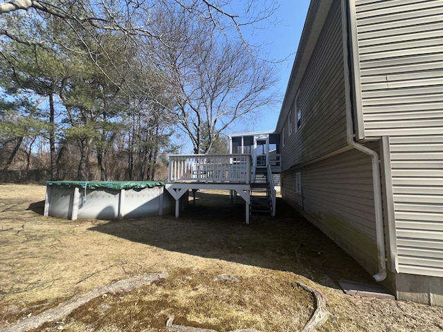 view of yard with a wooden deck and a covered pool