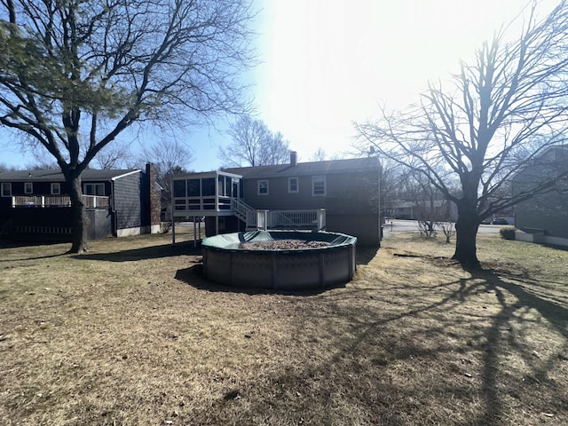 back of house with a sunroom and a wooden deck