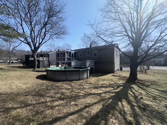 back of house featuring a covered pool, a deck, and a sunroom