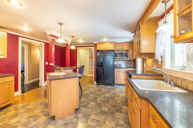 kitchen featuring a sink, stainless steel microwave, black fridge with ice dispenser, dark countertops, and glass insert cabinets