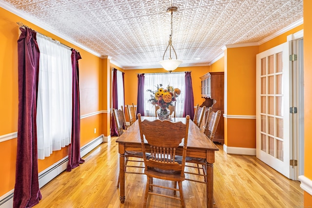 dining area with a baseboard radiator, an ornate ceiling, baseboards, and ornamental molding