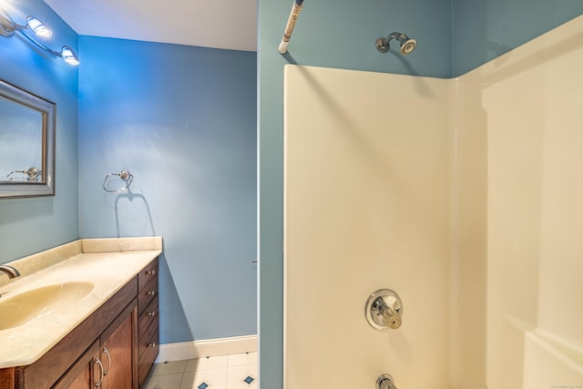 bathroom with tile patterned flooring, vanity, a shower, and baseboards