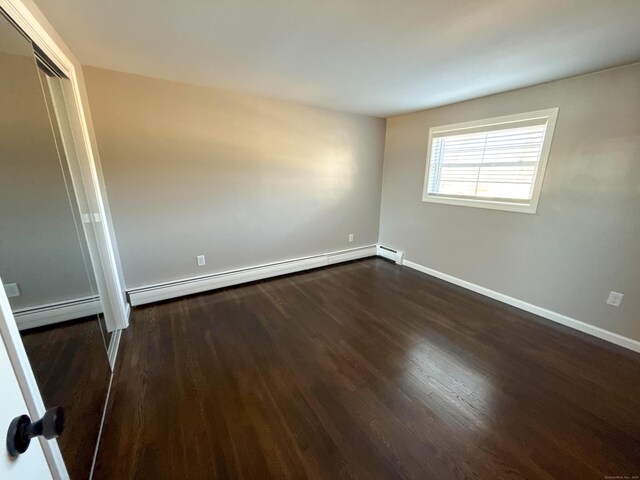 223 Rte 169, Woodstock, CT 06281 - unfurnished room featuring a baseboard heating unit, dark wood-style floors, and baseboards