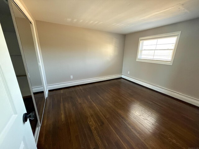223 Rte 169, Woodstock, CT 06281 - unfurnished bedroom with dark wood-style floors, baseboards, a closet, and a baseboard radiator