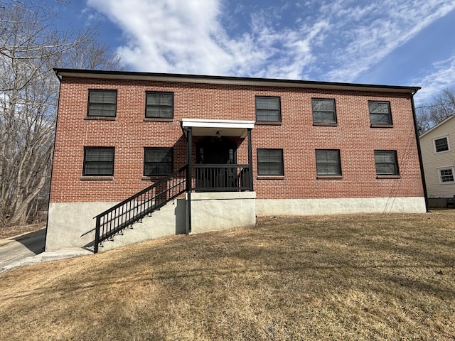 exterior space with brick siding and a front lawn